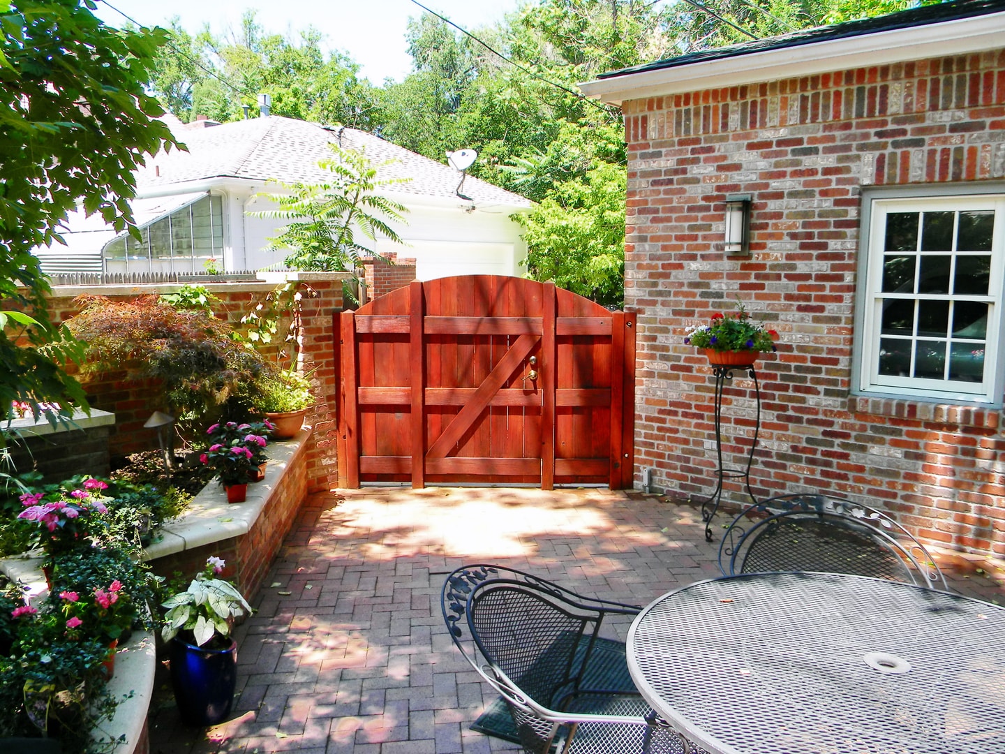 Richly stained cedar gate and fence on brick patio